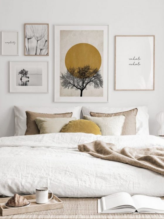 mur de cadres au dessus de lit blanc