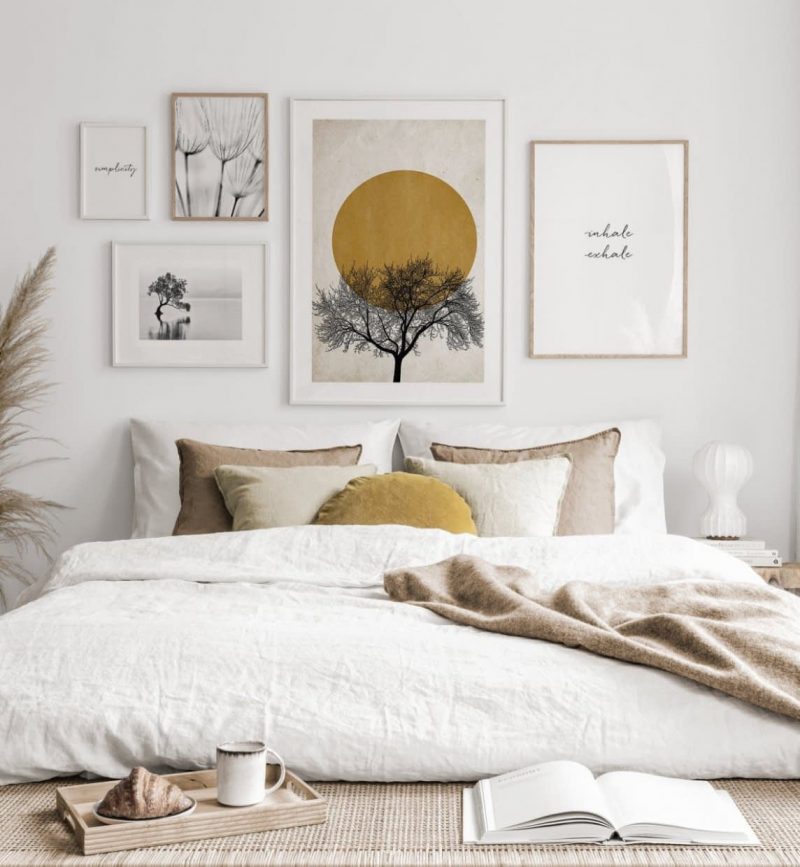 mur de cadres au dessus de lit blanc
