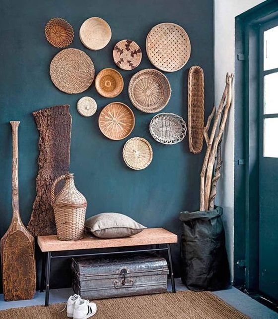 paniers en osiers et objets déco en bois pour décorer le mur bleu pétrole de ce hall d'entrée