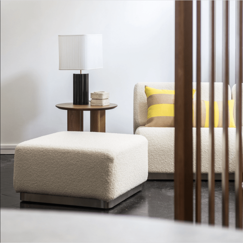 coin de salon moderne avec pouf en laine bouclée et bout de canapé en bois
