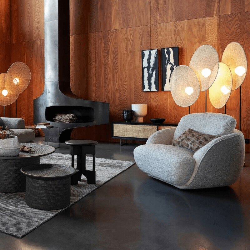 fauteuil en laine bouclée dans un grand salon avec cheminée métallique