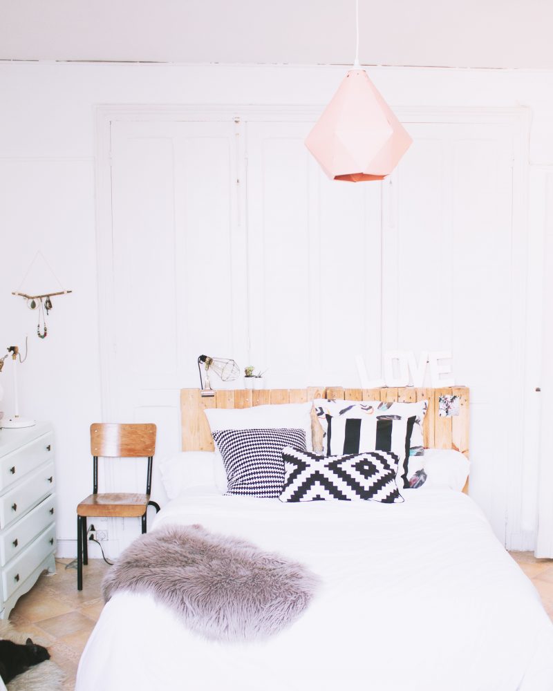 chambre adulte blanche avec mobilier vintage et tête de lit en palette en bois recyclé