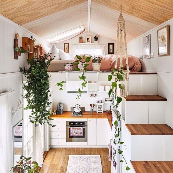 aménagement mezzanine en coin nuit de style bohème au dessus d'une cuisine scandinave en bois