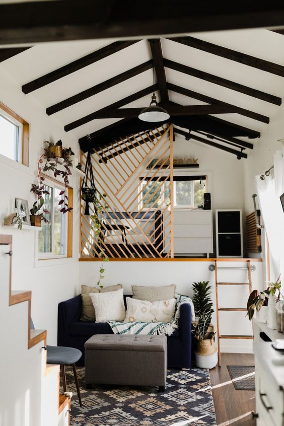 aménagement mezzanine sous les toits cachée derrière une claustra en bois et accessible avec une petite échelle