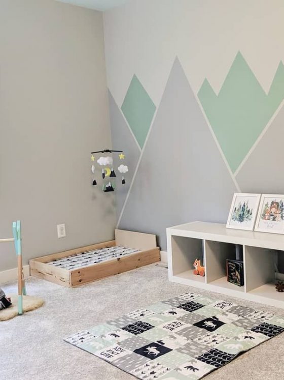 chambre bébé montessori de couleurs pastel avec graphiques au mur