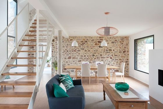 un espace ouvert moderne avec mobilier contemporain et mur en pierre apparente