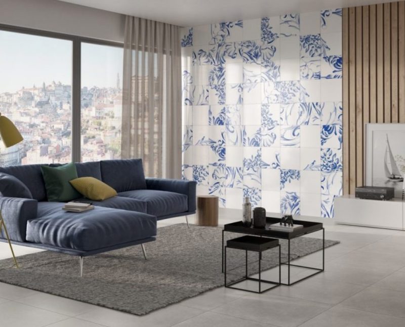 panneaux en céramique blanc et bleu au mur d'un salon avec grand canapé bleu
