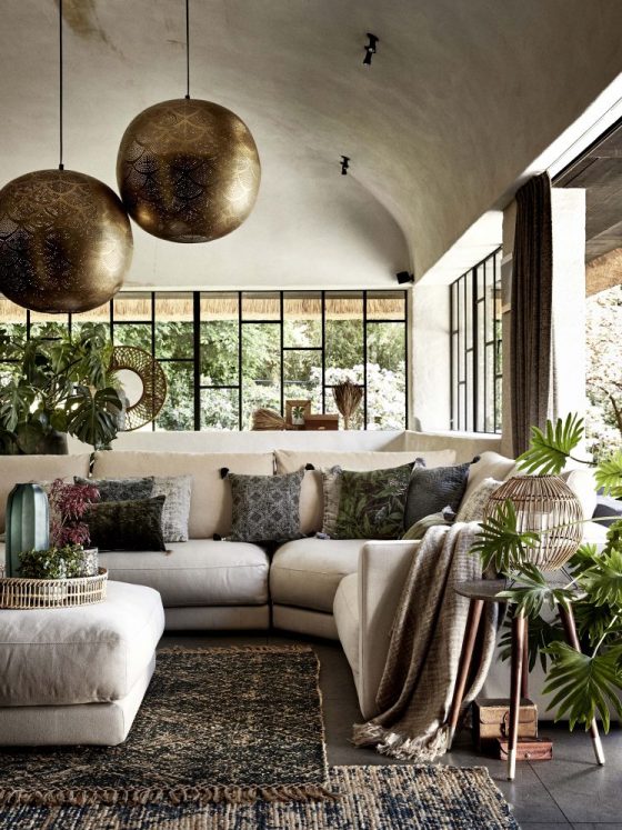 déco bohème chic dans un salon aux tons foncés décoré de plantes vertes