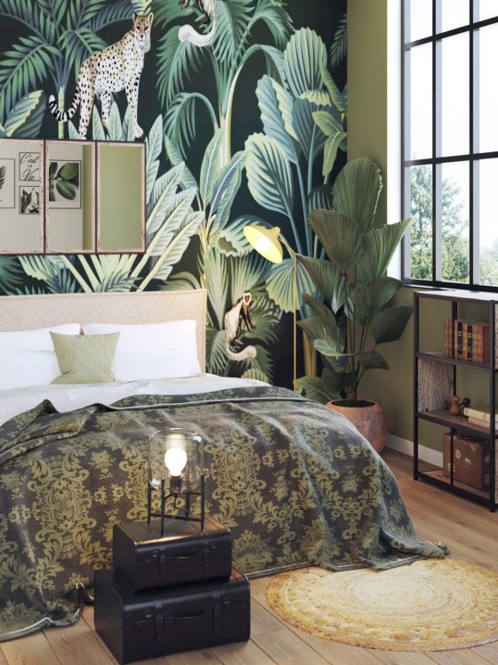 Le lit deux places se pare de draps aux motifs végétaux, avec un sol en parquet et du papier peint tropical au-dessus de la tête de lit