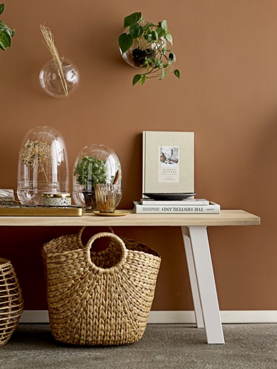 déco chaleureuse aux couleurs du printemps avec un mur beige et un fauteuil en osier