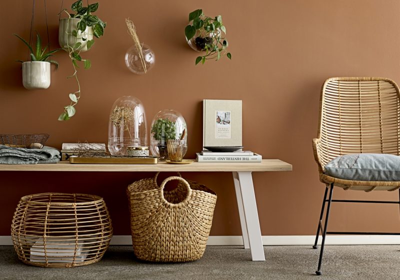 déco chaleureuse aux couleurs du printemps avec un mur beige et un fauteuil en osier