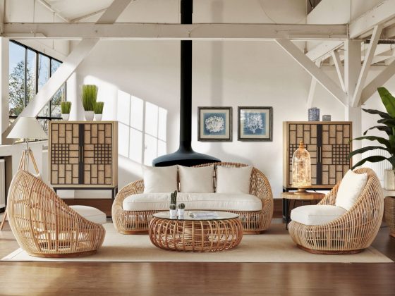 Un salon contemporain, grand et lumineux, avec un poêle suspendu, un canapé et des fauteuils en rotin