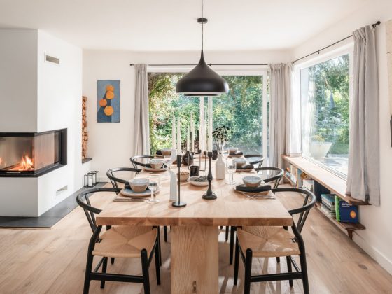 La salle à manger scandinave est aménagée avec des chaises nordiques et une grande table en bois