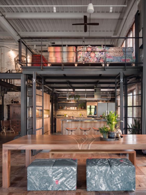 aménager un loft industriel dans une ancienne usine, avec de grands espaces, des matériaux bruts et des touches de couleurs vives