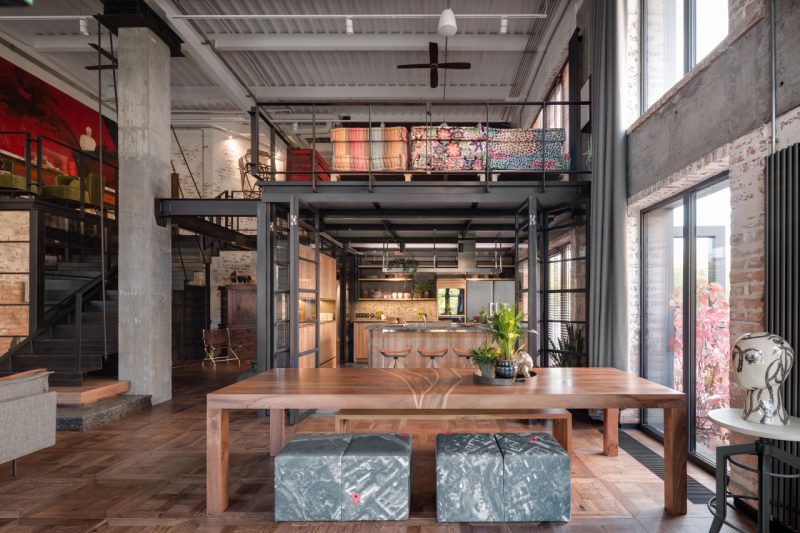 aménager un loft industriel dans une ancienne usine, avec de grands espaces, des matériaux bruts et des touches de couleurs vives